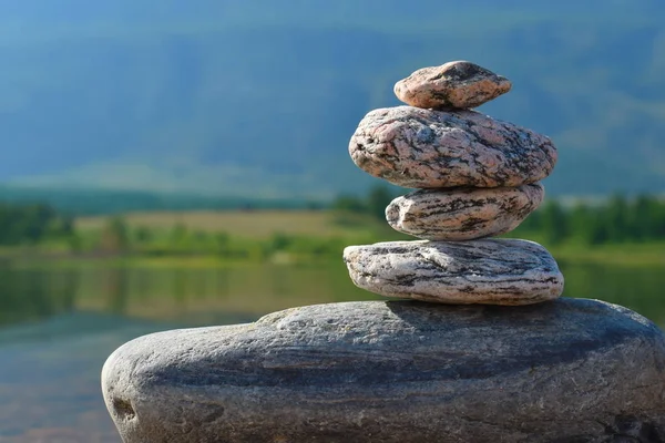 Stones meditation figures. Symbolical statue of several stones. Tradition to collect  stones in private. Beautiful water landscape background with natural stones.