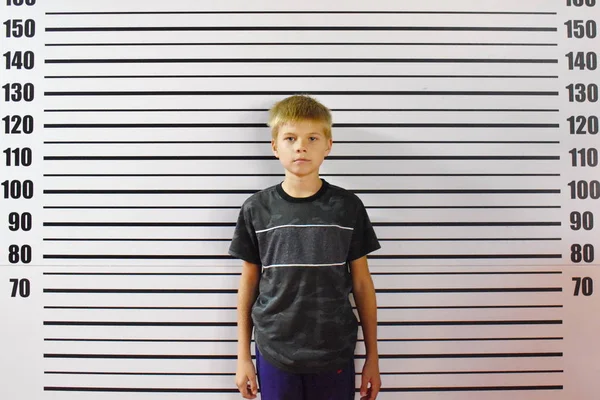 A convicted teenager is standing against a wall in the police. — Stock Photo, Image