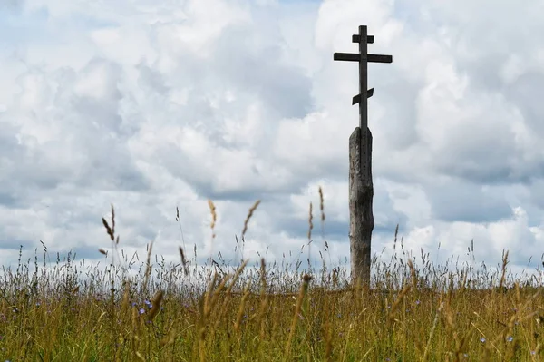 Drewniany krzyż prawosławny na stanowisku w polu. — Zdjęcie stockowe