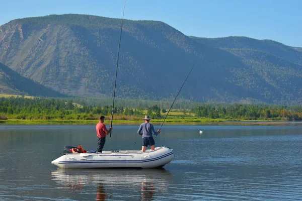 Los pescadores pescan al girar en un gran lago . — Foto de Stock