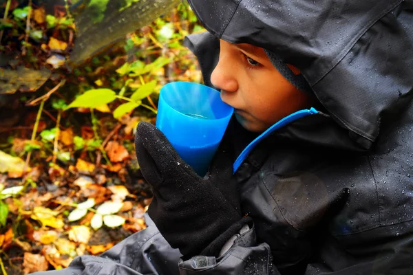 Boy frozen in a jacket is drinking hot tea outdoor. — Stock Photo, Image