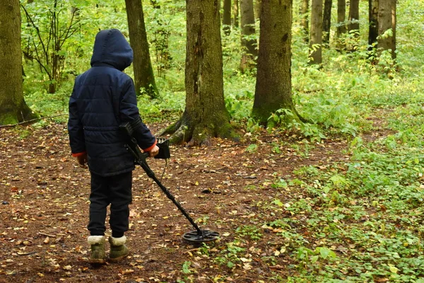 Niño con detector de metales en el bosque de otoño. Pasatiempo masculino —  Fotos de Stock