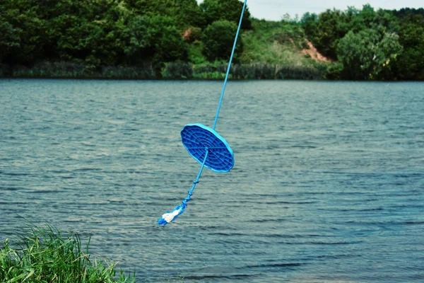 Corda balançar em uma árvore acima da água. Parque infantil caseiro no — Fotografia de Stock