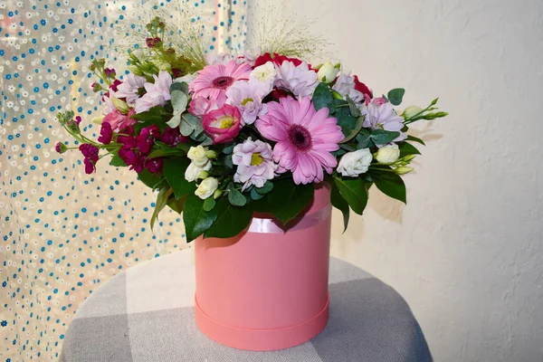 Arreglo floral en una caja de sombreros sobre la mesa . — Foto de Stock