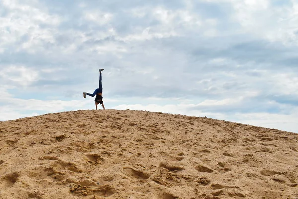 Beach children's games. Summer fun holidays.A girl climbs a moun — Stock Photo, Image