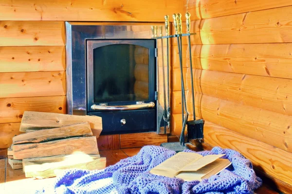 Acogedor interior de una casa de madera con estufa. Plaid en una silla —  Fotos de Stock