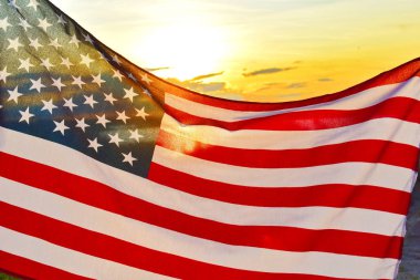 Gün batımında gökyüzünde Amerikan bayrağı sallamak.