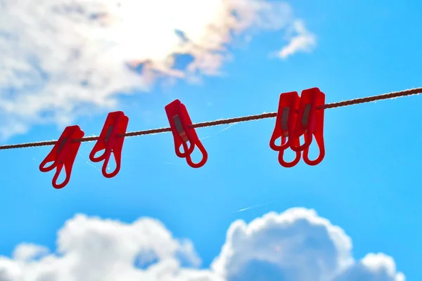 Rode wasknijpers op een touw op een blauwe hemel. — Stockfoto