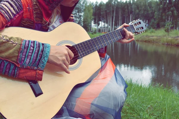 Donna con una chitarra vicino all'acqua. Una persona suona la chitarra in t — Foto Stock