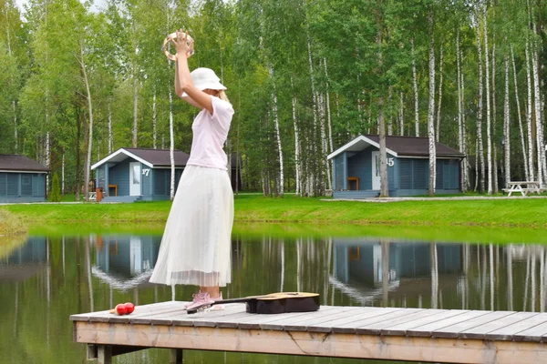 Una donna sta ballando sul molo. Immagine romantica vintage con una bella — Foto Stock