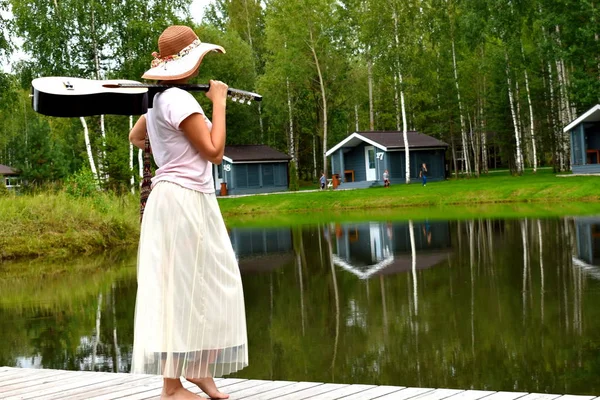 Giovane donna con una chitarra sulla natura. Paese picnic all'aperto . — Foto Stock
