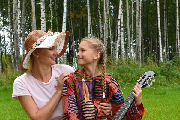 Madre feliz con una hija y una guitarra. Familia musical. Mamá w —  Fotos de Stock