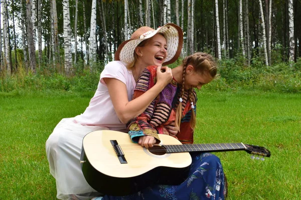 Madre felice con una figlia e una chitarra. Famiglia musicale. Mamma w — Foto Stock