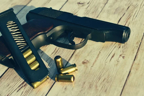 Pistola con balas sobre fondo de madera . — Foto de Stock