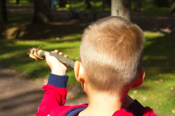 Chłopiec gra z Stick-Gun. Gry dla dzieci fotografowania na zewnątrz — Zdjęcie stockowe