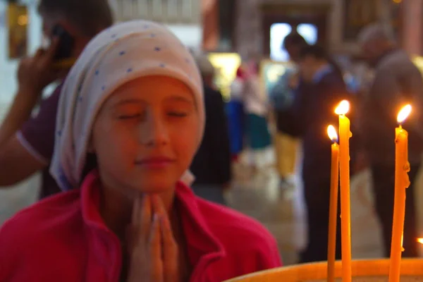 Uma rapariga na igreja está a rezar. Velas no templo. Oração a Deus — Fotografia de Stock