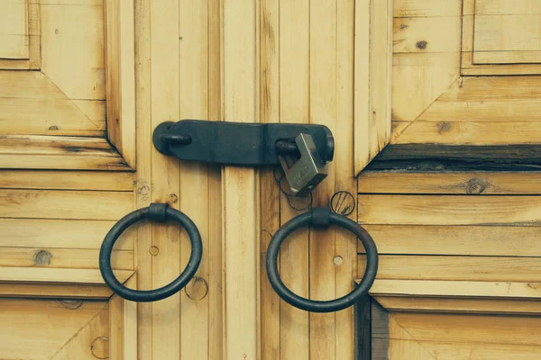 Puerta de madera vieja con un mango de metal tallado. — Foto de Stock