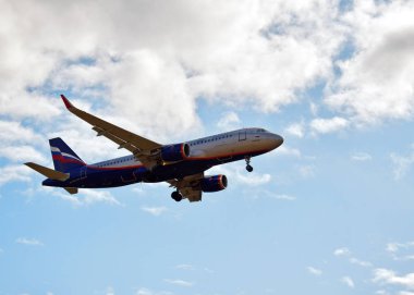 Bulutlarda mavi gökyüzünde bir uçak.