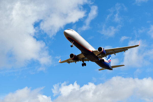 Airplane on a blue sky in the clouds.