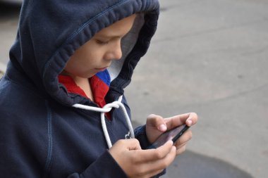 Çocuk dışarıyı aramak için mesaj yazıyor. Mobil iletişim.