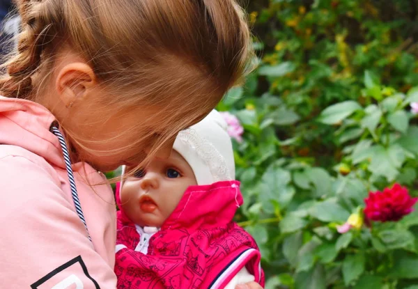 Mädchen mit einer Lieblingspuppe. schöne Puppe wie ein Baby. — Stockfoto