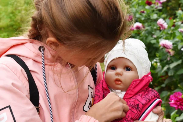 Mädchen mit einer Lieblingspuppe. schöne Puppe wie ein Baby. — Stockfoto