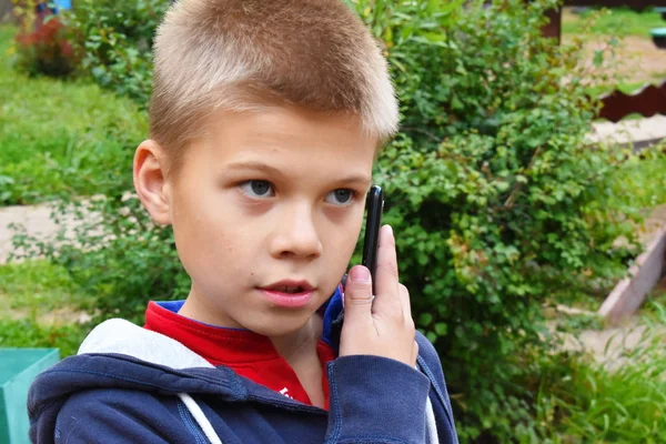 Seorang anak laki-laki berbicara di telepon di jalan close-up . — Stok Foto