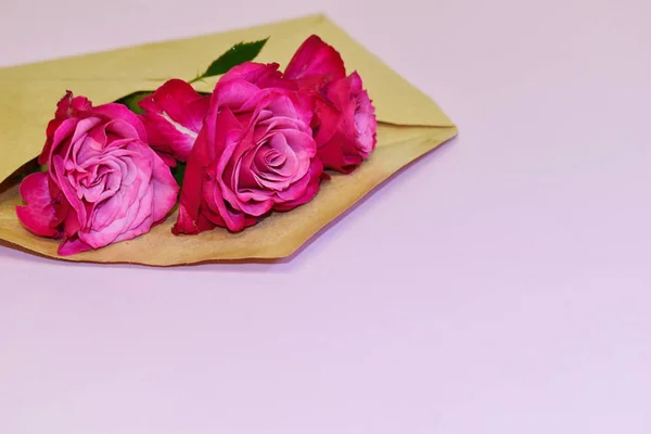 Prezent projektant kwiatowe tło z miejscem na tekst. Koperta papierowa z różą. — Zdjęcie stockowe
