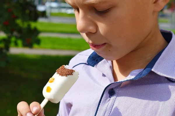 味のない合成アイスクリーム。少年は白いアイスクリームを食べている。 — ストック写真