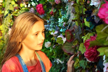 Çiçekli bir duvarda gizemli bir kapı. Kız ilginç bir şey buldu..