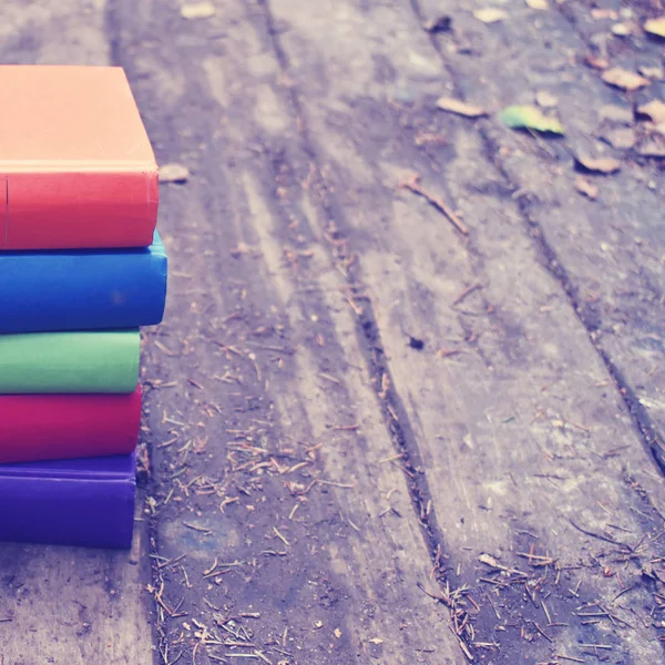 Libros de colores sobre un fondo de madera. Estilo retro con libros . —  Fotos de Stock