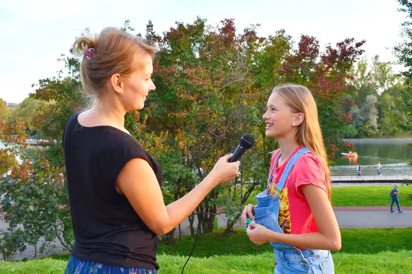 Meisjes interviewen. Televisie-verslaggeving in het park. — Stockfoto
