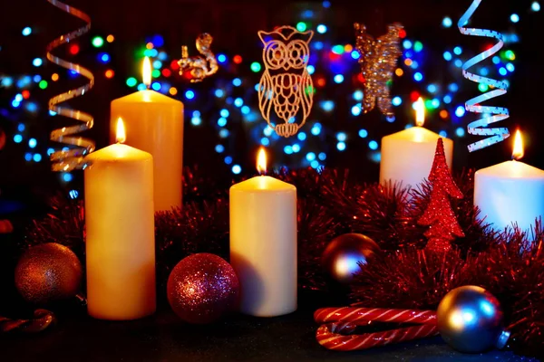 Новогодний стол с декором. Свечи, часы и рождественские игрушки с огнями — стоковое фото