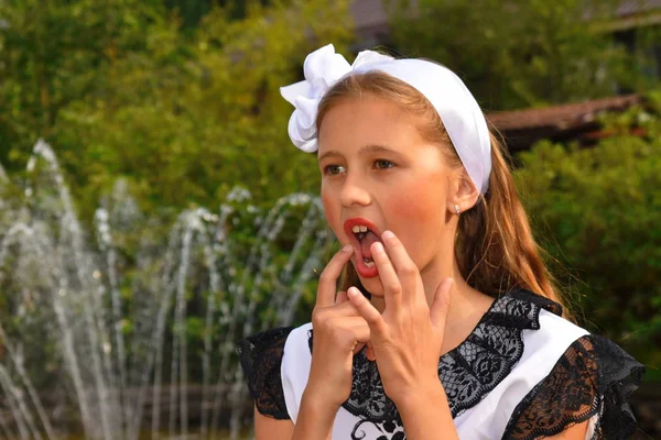 Hermosa modelo adolescente corrige el maquillaje en sus labios. Agencia de modelaje infantil . — Foto de Stock