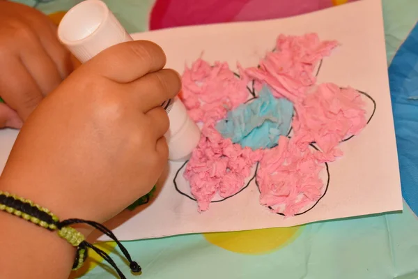 Ребенок сам делает бумажное ремесло. Тонкая моторика пальцев. Развитие детей в детском саду . — стоковое фото