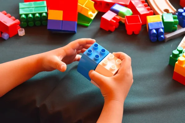 Bir çocuk renkli küplerle oynar. Çocuk plastiği, çok renkli yapıcı..