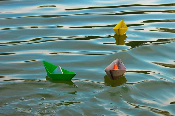 Kolorowe papierowe łodzie w wodzie o zachodzie słońca. — Zdjęcie stockowe