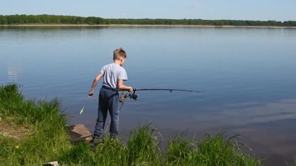 Fiam, egy tó partján horgászik fonásra. Halászati hobbik gyermekek számára... — Stock videók