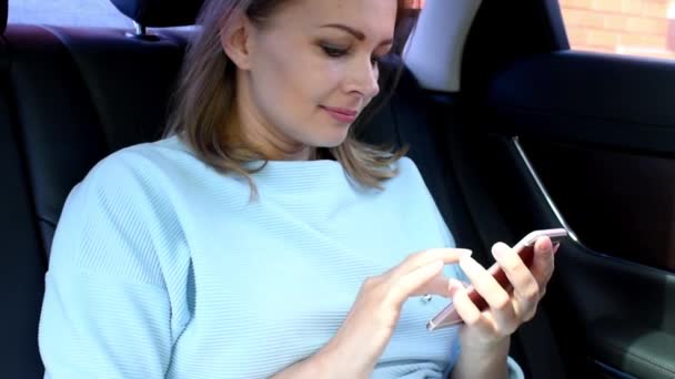 Жінка з телефоном в машині на пасажирському сидінні — стокове відео