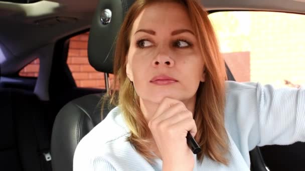 Молода жінка сидить в машині і думає про проблему . — стокове відео