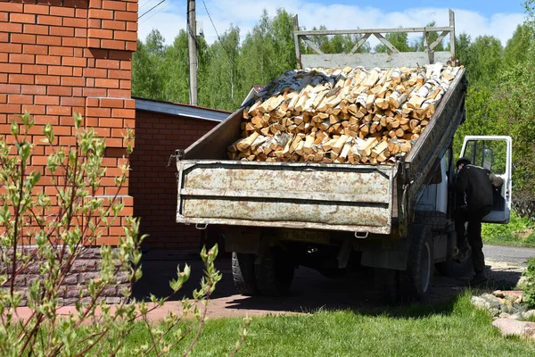 Kırsal yaşam için odun kırmış bir kamyon. Arabanın arkasında doğranmış kütükler var.