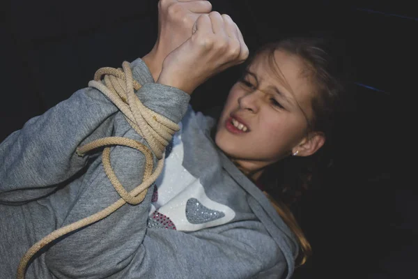小さな被害者の少女の手にロープを。子供に対する暴力。誘拐された — ストック写真