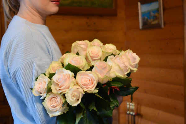 Woman with bouquet of delicate white roses. cream flower bouquet for a birthday