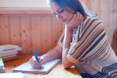 Genç bir öğretmen ödevlerini kontrol eder. Eve ödev yazmak için