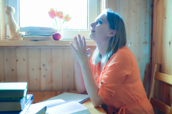 Una giovane donna scrive un libro a casa. Pensare al problema — Foto Stock