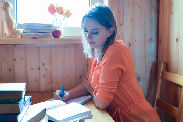Una donna scrive un libro. L'insegnante controlla i compiti. — Foto Stock