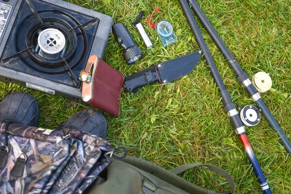 Cosas cazadoras en la hierba. Un conjunto necesario de artículos para el viaje extremo natural . — Foto de Stock