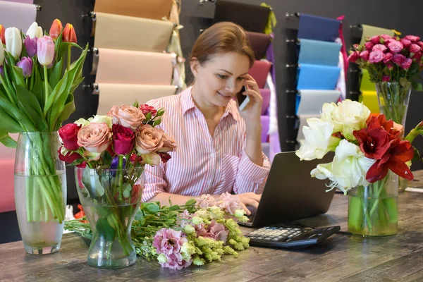 Flower delivery service. florist seller with a telephone. Interior colors — Stock Photo, Image