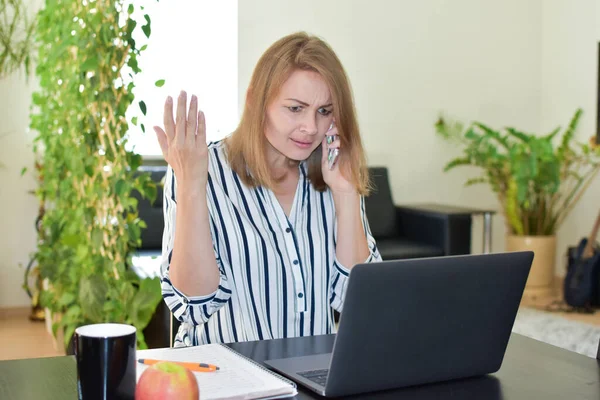 La mujer está indignada por el teléfono en casa en el ordenador, dificultades de trabajo y problemas . —  Fotos de Stock