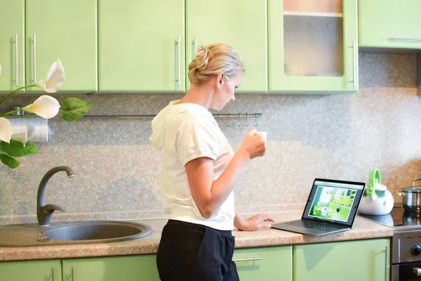 Vrouw freelance interieur ontwerper in de keuken. werk van thuis uit online — Stockfoto